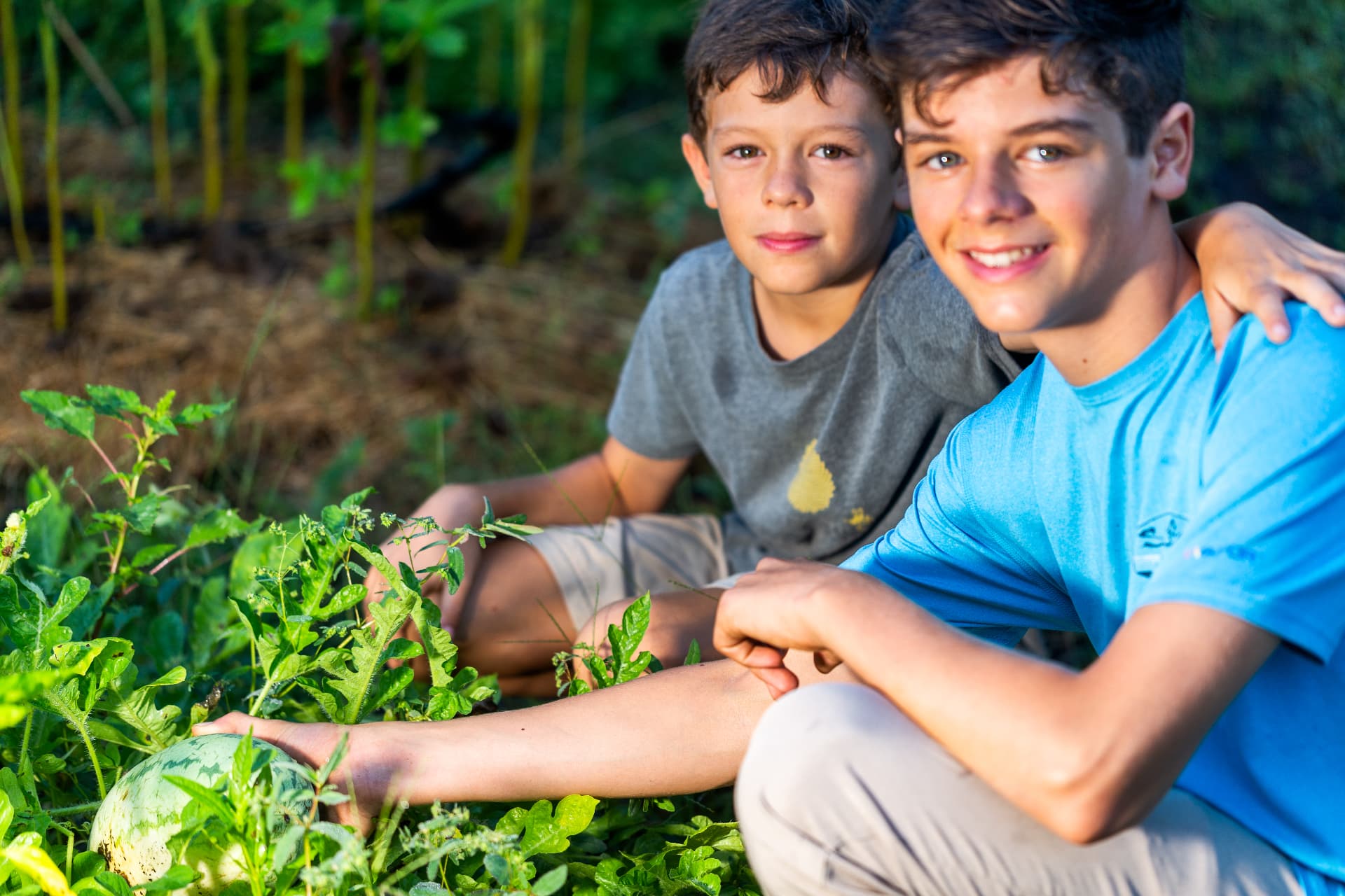 Two students in the school garden with a watermelon they have grown